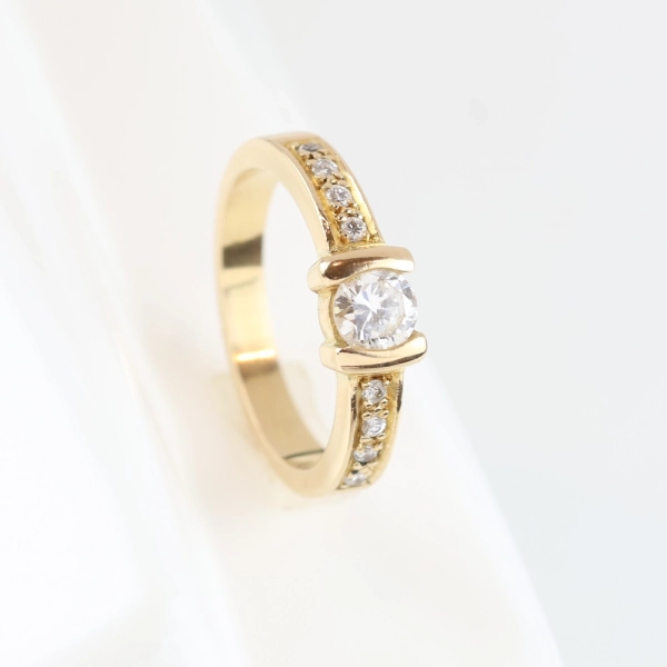 Anillo de oro amarillo 18K con diamante solitario y diamantes talla brillante