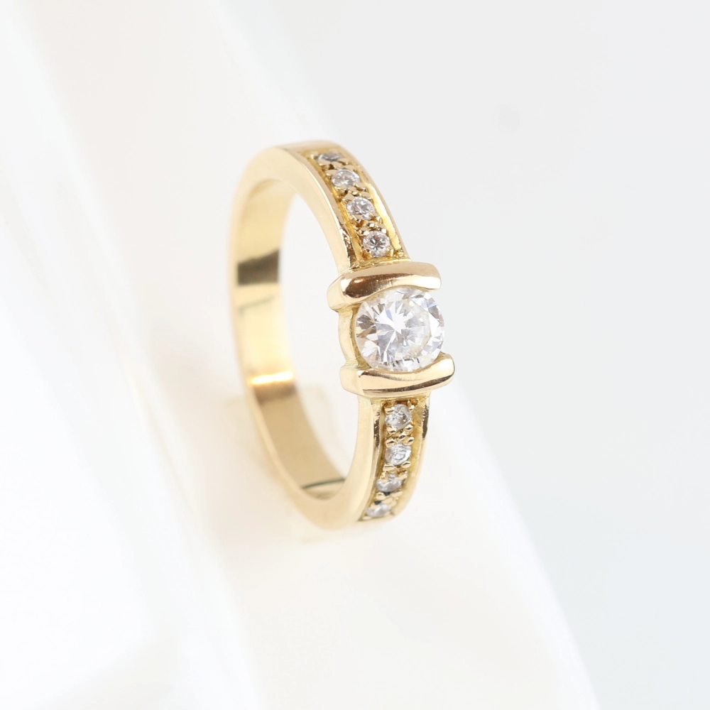 Anillo de oro amarillo 18K con diamante solitario y diamantes talla brillante